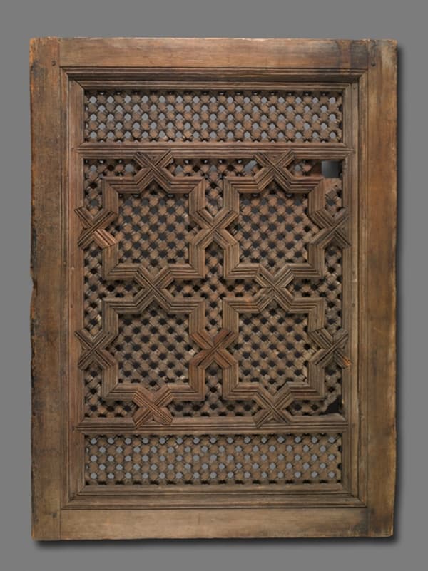 A work made of carved wood with iron bolts.