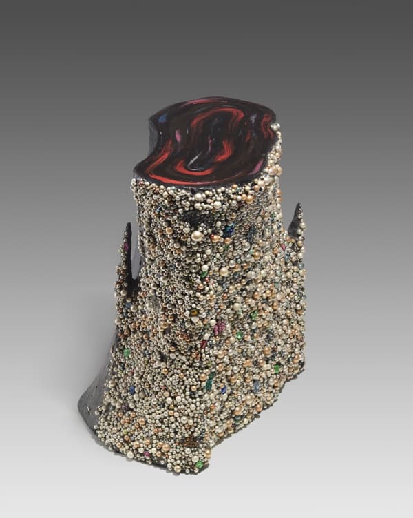 A work made of acrylic, faux pearls, costume jewelry on papier-mâché.